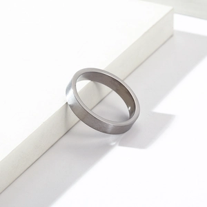 Détail d'une bague en acier titane de 4mm avec finition brossée mate sur décor géométrique