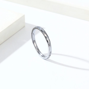 Nahaufnahme eines minimalistischen Wolframstahlrings mit Diamantschliff und geometrischer Textur