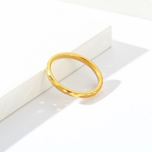 Makro-Detail des goldenen Wolframrings mit rautenförmiger Oberfläche und elegantem Glanz