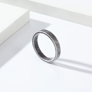 Détail macro d'une bague en acier titane brossé mat de 4mm au fini argent antique
