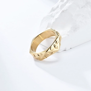 Detalle de anillo de acero de titanio dorado con motivos celestiales de luna y estrellas