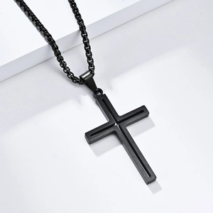 Détail d'un pendentif croix noir mat sur une chaîne box pour un look punk sobre