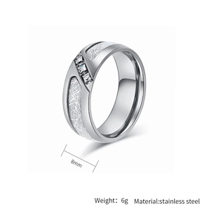 Detalle del anillo de acero de 8 mm con textura de meteorito y tres circonitas cuadradas