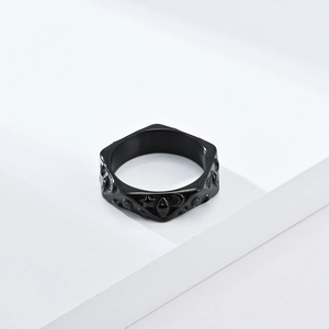Anillo de acero inoxidable negro mate con patrones celestiales de estrellas y luna en pedestal