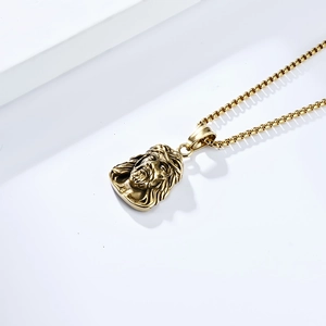 Macro detail of golden Jesus head pendant with textured relief on a classic Venice chain