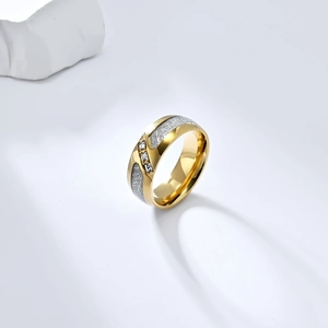 Detalle de anillo de titanio dorado con incrustación de meteorito y tres circonitas