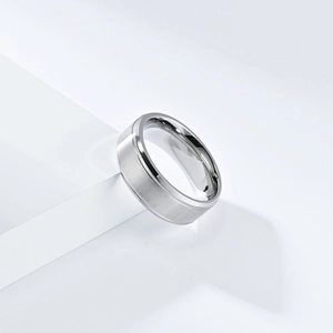 Bague minimaliste argentée mate brossée avec bords polis sur un socle d'exposition