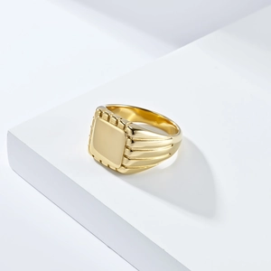 Detailed view of square gold signet ring with vertical stripes on side and mirror finish