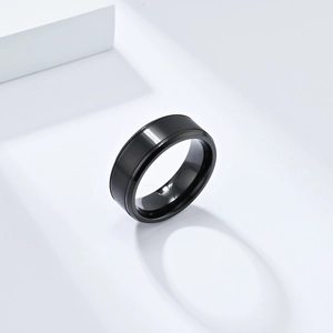 Détail d'une bague en acier titane noir brossé mat avec des bords biseautés