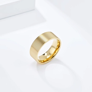 Detailed view of gold titanium ring featuring horizontal grooved texture and polished inner band