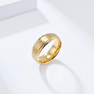 Detailansicht eines matt gebürsteten goldenen Wolframrings mit polierten Kanten auf Sockel