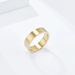 Gros plan d'une bague en titane doré mat de 6mm avec une texture brossée élégante