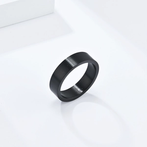 Gros plan sur une bague de 6mm en acier titane noir brossé mat sur support géométrique