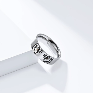 Macro detail of silver animal ring featuring black and white tiger stripes and amber bead eyes