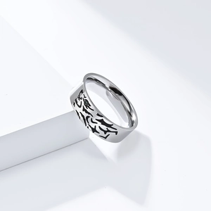 Detail shot of a titanium steel ring with tiger stripes and a green gemstone inlay