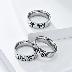 Detailed macro view of silver animal rings with vibrant gemstone eyes on a white pedestal