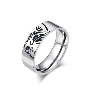 Silver animal ring with tiger face engraving and small blue sapphire eyes on white background