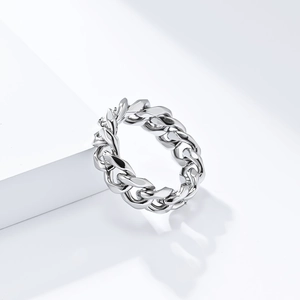 Macro shot of silver titanium steel curb chain ring on a white geometric stand