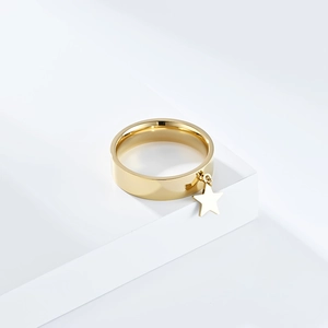 Detailed view of a polished gold star pendant on a minimalist stainless steel ring