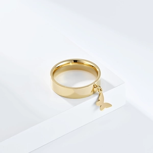 Polished gold stainless steel ring with elegant hanging butterfly charm on white base