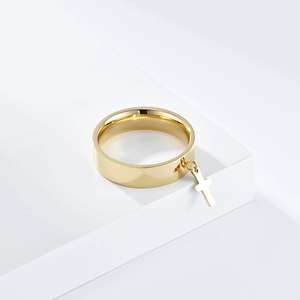 Close-up of golden stainless steel flat band ring featuring a movable cross charm detail