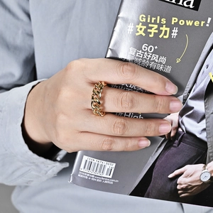 Minimalist polished gold Cuban link chain ring worn by a model on a fashion magazine