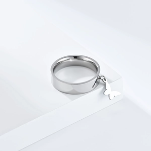Detailed view of silver stainless steel wide band ring with a hanging butterfly charm detail