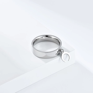 Detailed view of a polished silver crescent moon pendant attached to a flat steel band ring