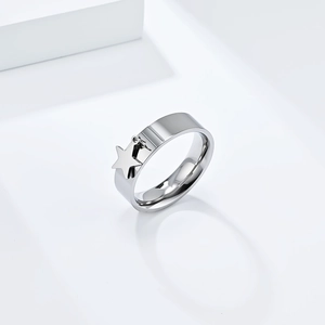 Macro detail of polished stainless steel ring featuring a dangling silver star charm