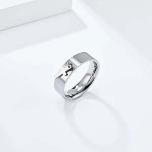Polished titanium steel ring with hanging cross pendant on a white geometric background