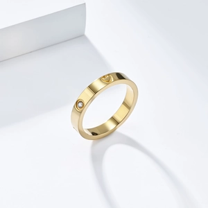 Detailed macro view of gold-plated ring with screw motifs, heart cutout and small zircon