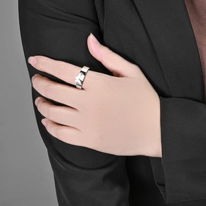 Detailed view of a silver butterfly charm ring worn on the finger with a polished finish