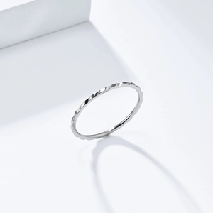 Dettaglio macro di un anello impilabile minimalista da 1mm con design a corda argento