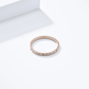 Primer plano de anillo de titanio oro rosa con textura geométrica y cristales pequeños