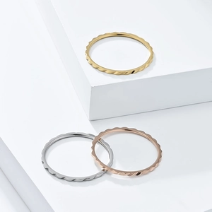 Dettaglio di anelli impilabili ondulati da 1 mm in oro, argento e oro rosa