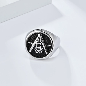 Macro detail of silver Masonic signet ring with compass symbol and G letter