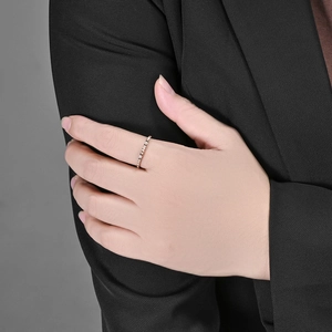 Elegante anillo apilable en oro rosa con cristales pavé blancos brillantes en la mano