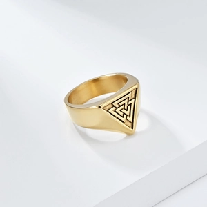 Macro detail of golden stainless steel Valknut signet ring with engraved Viking knot symbol