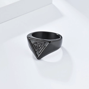 Matte black stainless steel Viking Valknut ring on a minimalist white geometric display