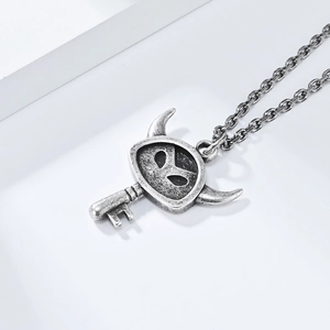 Close-up of vintage silver devil key pendant on a chunky stainless steel O-chain necklace