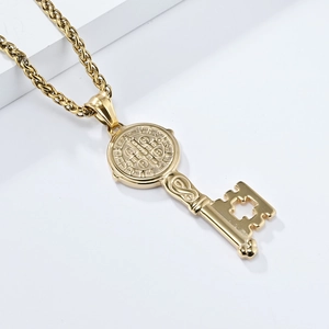 Macro detail of golden Saint Benedict medal key pendant with ornate cross cutouts