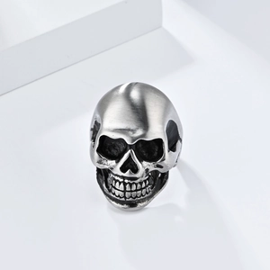 Detailed macro view of matte brushed stainless steel skull ring with gothic punk design