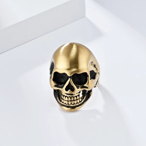 Macro detail of matte gold brushed skull ring with vintage punk style textures