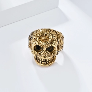 Nahaufnahme eines goldenen Vintage-Totenkopfrings mit aufwendigen Blumen-Schnitzereien