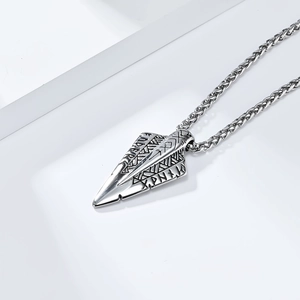 Macro shot of vintage silver Viking arrow pendant with engraved Runes and wheat chain