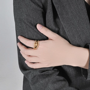 Anello impilabile dorato con rilievo a stella vintage su sfondo blazer grigio