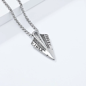 Detailed view of Viking rune engravings on an arrowhead pendant in vintage silver steel