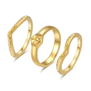 Set di tre anelli dorati con emblema a stella e design a onde su sfondo bianco