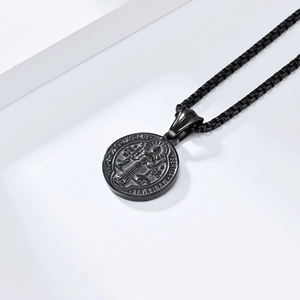 Close-up of black Saint Benedict religious pendant showing fine engraved details