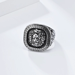 Retro stainless steel lion head ring with Greek Key pattern border on white platform